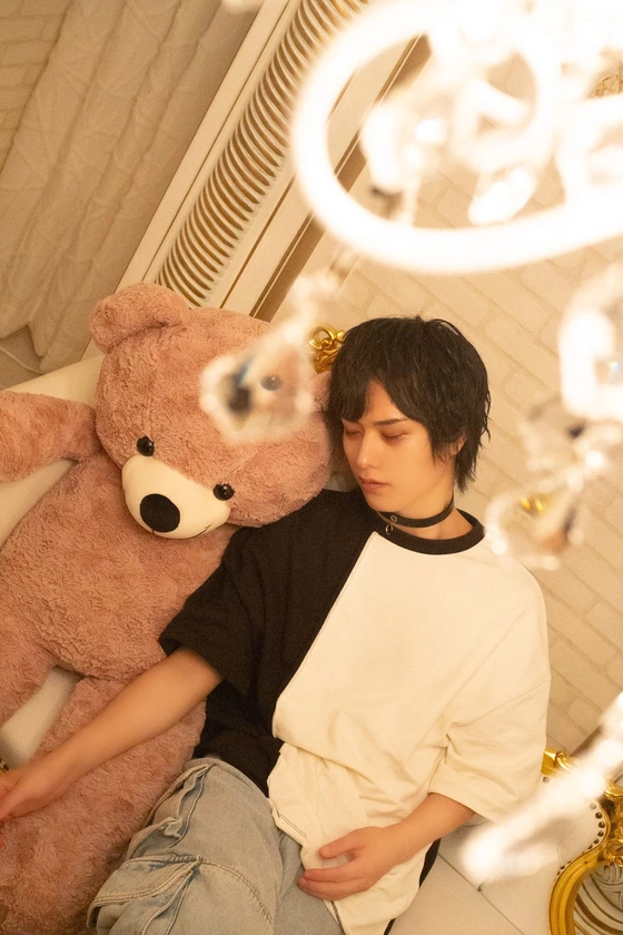 室内でクマのぬいぐるみと写る一枚